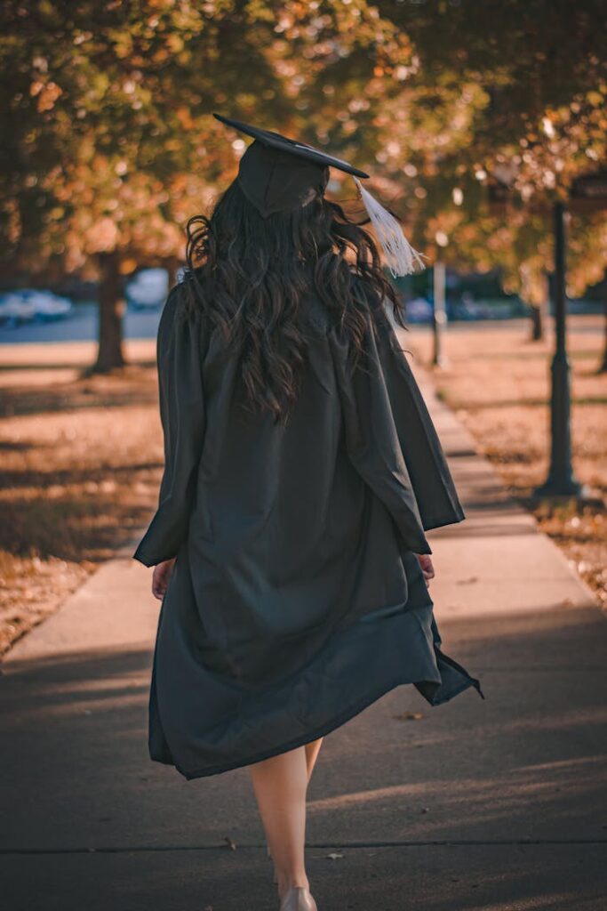 pexels photo 3186386 Back view of a graduate walking in an autumn park in academic dress.
